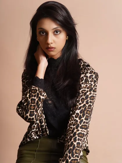 A closer portrait from the leopard print shoot, showing the soft, natural makeup and the effortless, layered hairstyle.
