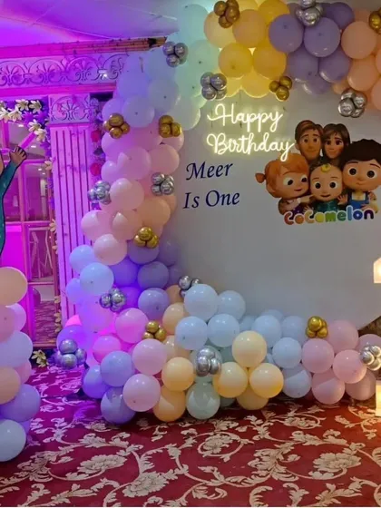 A pastel Cocomelon theme for Meer's first birthday. This decoration features a gentle color palette, a circular backdrop with characters, a light-up number '1', and an organic balloon garland.