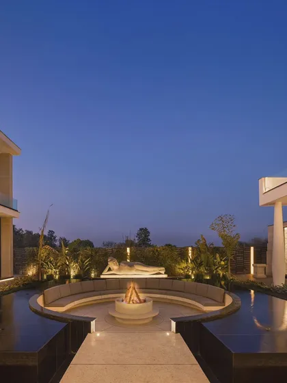 As dusk settles, the fire pit is ignited, transforming the space into a warm and inviting lounge. This image, featured in a story on 'The Luxury Disruptors,' highlights our commitment to creating spaces that are not just visually stunning but also enhance the lifestyle of our clients.