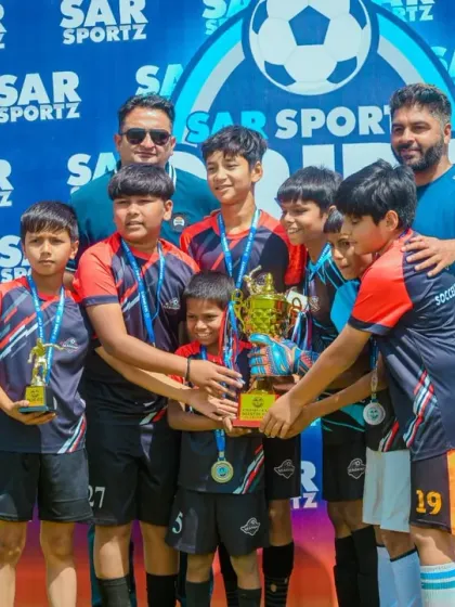 This team is all smiles as they gather around their hard-earned championship trophy.