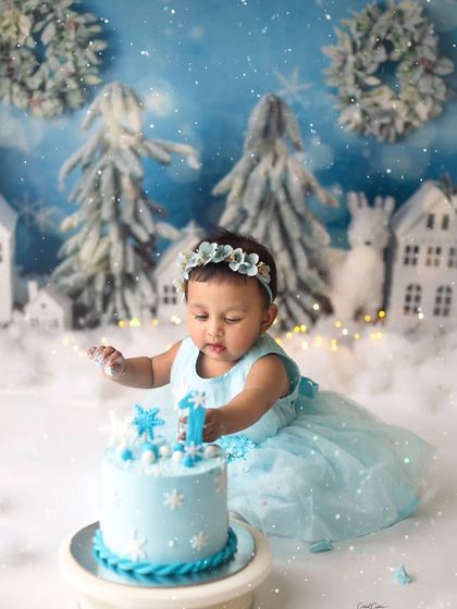 A little princess in a snowy paradise. She was so gentle and curious exploring her snowflake-adorned cake during this winter wonderland first birthday session.
