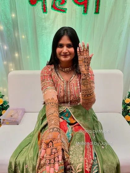 The lovely bride showing her full bridal mehendi, a result of hours of dedicated work.