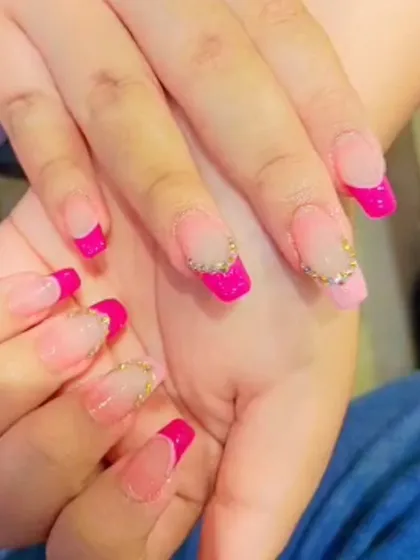 Bright pink French tips on square nails, with a line of delicate rhinestones at the base of the accent nails for a touch of sparkle.
