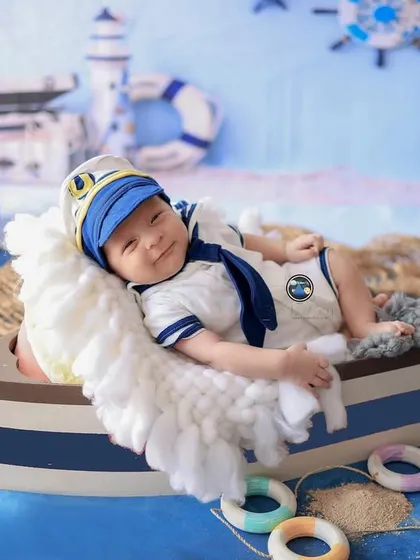 Ahoy, little captain. This sailor-themed newborn shoot is a perfect example of a fun, creative session for a baby boy. From the tiny sailor outfit to the boat prop and nautical background, every detail is planned.