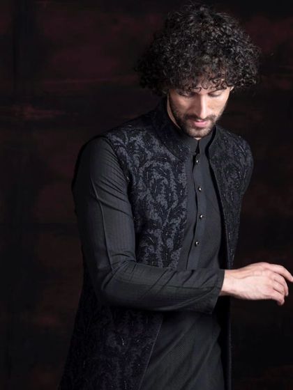 A black-on-black look featuring an embroidered waistcoat. This ensemble is perfect for making a statement at weddings or festive events, offering a world of sophistication.