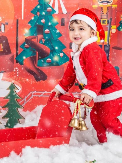 This little Santa is ringing the jingle bells to spread some holiday cheer.