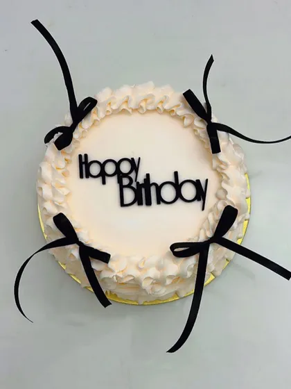 Tied up in sweetness! This minimalist cake with delicate black ribbon bows is a perfect example of chic and modern design.