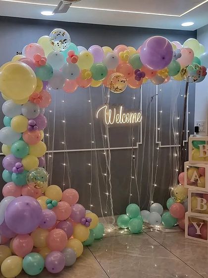 This image shows the scale of the pastel balloon arch, perfect for creating a dedicated photo corner in your home.