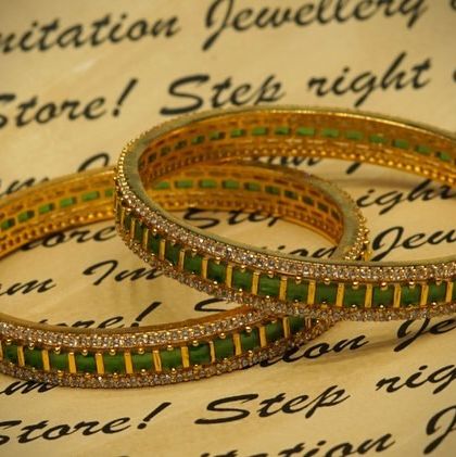 Another look at the beautiful green stone and AD bangles, showcasing their fine craftsmanship and brilliant shine against a textured background.