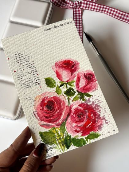 The final image of my watercolor rose painting, showing the finished piece next to my brush and palette.