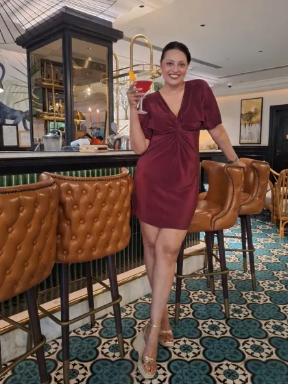 Enjoying a cocktail in a chic maroon dress. This is a great example of a versatile piece that can take you from day to night.