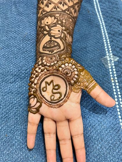 A close-up of the back of the hand, featuring the couple's initials 'MS' in a circle.