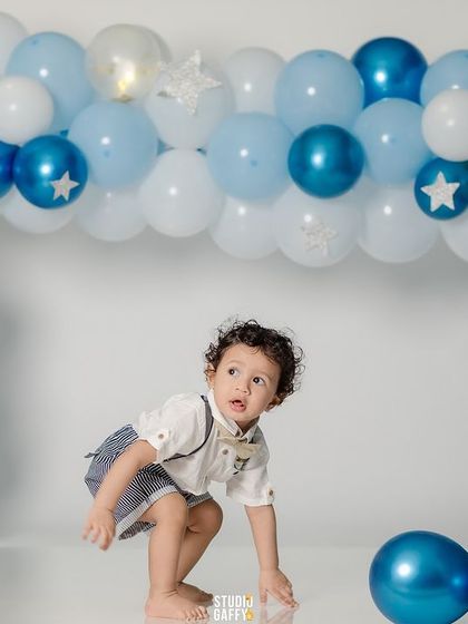 The birthday boy exploring his balloon-filled set before the cake arrives.