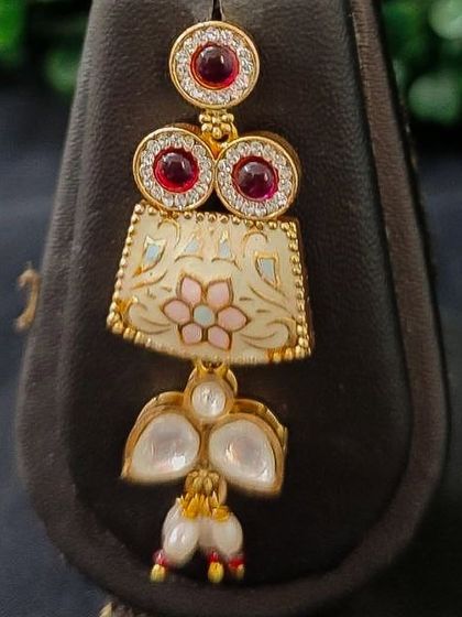 A close-up of the earring from this set, showing the beautiful floral enamel detail.