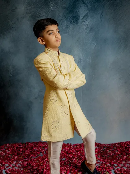 Posing with confidence in our pale yellow embroidered sherwani. The detailed threadwork and classic silhouette make this a go-to choice for parents looking for a traditional yet stylish wedding outfit for their son.