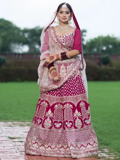 This beautiful pink bridal lehenga is perfect for a day wedding. The mirror work and thread embroidery create a sparkling effect, ensuring you shine on your special day.