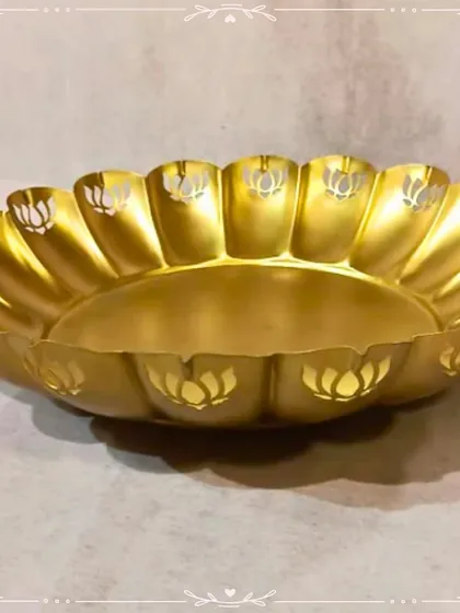 A large golden urli with a lotus-petal-shaped rim. This is a classic and elegant piece, perfect for floating flowers and candles to create a serene ambiance.