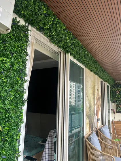 Another view of the balcony, showing how the green wall panels create a cohesive, lush look that enhances the modern architecture.