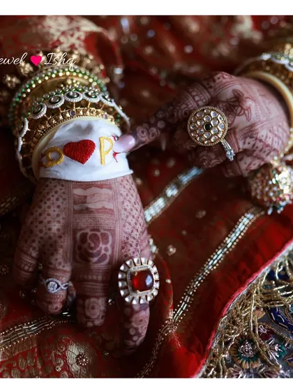 A detailed shot of the bride's hands, showcasing her beautiful henna, custom kaleeras, and statement jadau rings.