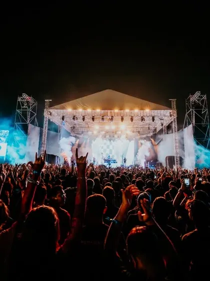 A wide shot of the Dream Theater concert, showing the full stage setup and the massive, energetic crowd.