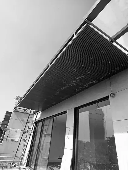 The framework for a terrace overhang being installed, showing the exposed steel structure before the final cladding and glass are fitted.