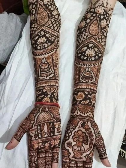 A classic bridal design with full arm coverage. It features traditional symbols like bells, a kalash, and architectural domes, perfect for a traditional wedding ceremony.