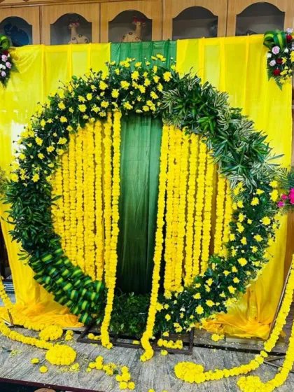 A full view of the circular Haldi stage, flanked by tall stands also decorated with marigold garlands. The setup is bright, traditional, and perfect for the happy occasion.