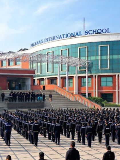 The morning assembly at Prayag International School, set against the backdrop of the main building's modern facade. This image captures the scale and life of the campus we designed.
