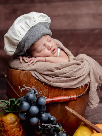 Let's have some fun. I have a collection of adorable props for creative themes, like this tiny masterchef setup, complete with a chef's hat and a bucket of fresh fruit for a playful portrait.