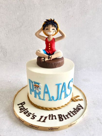 A cake for a "One Piece" fan, featuring a handcrafted figurine of the main character, Luffy, on top.