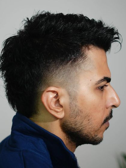 A side profile of the mullet, highlighting the clean fade and the textured, longer hair at the back.