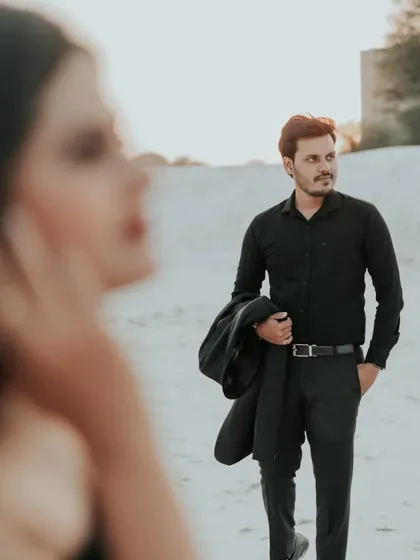 An artistic shot with the bride out of focus in the foreground, drawing the eye to the groom. This creative composition adds depth and a narrative feel to the photo series.