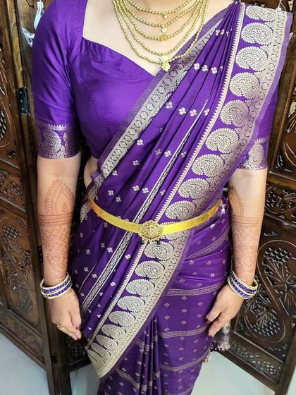 A close-up of the body-hugging drape, showing how the pallu is pleated and pinned neatly on the shoulder.