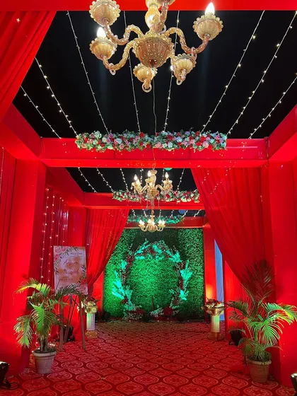 Another view of the red entrance tunnel, highlighting the hanging chandeliers and floral wreaths that add layers of elegance to the design.