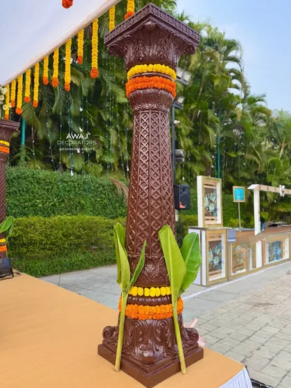 A detailed shot of the mandap pillar, showcasing the traditional carvings and the fresh flower decorations.