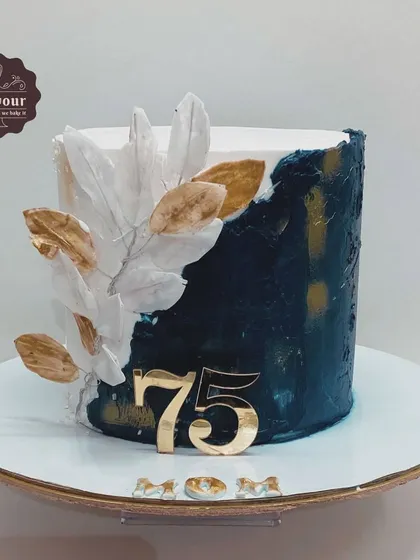 A Gulab Jamun fusion cake for a 75th birthday. This cake combines a traditional Indian sweet with modern cake design, featuring a dark blue and white textured finish.
