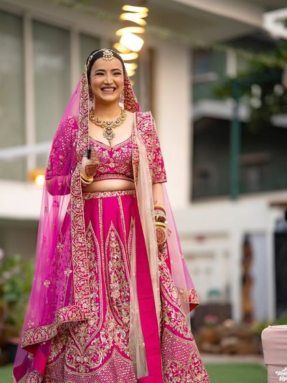 A happy, candid shot of the bride in her stunning pink lehenga, capturing her infectious smile.