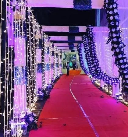A dramatic entrance walkway for an evening reception. The path is lined with walls of fairy lights, creating a sparkling tunnel effect that wows guests.