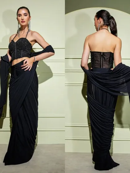 A bold and beautiful black drape saree set. It features a structured halter-neck corset blouse with a front zipper, paired with a gracefully draped skirt.