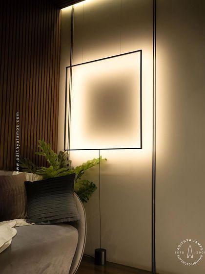 A duplicate of image 100, this view captures the full context of the suspended frame light in a cozy living room setting.