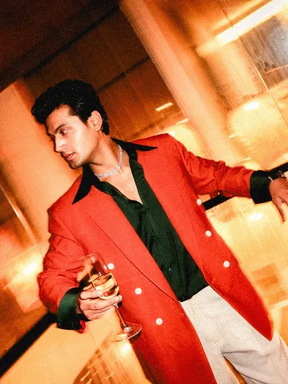 Another angle of the celebratory outfit, highlighting the dark green cuffs and collar that add a unique, custom touch to the double-breasted blazer.