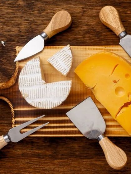 A professional studio shot of a cheese board featuring wedges of Brie and Swiss cheese, surrounded by specialized cheese knives. This image highlights the quality of both the ingredients and the serving tools I provide.
