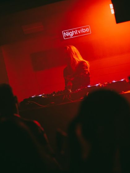 A wide shot from the back of the room, showing me on stage under the Nightvibe sign. It highlights the scale of the event.