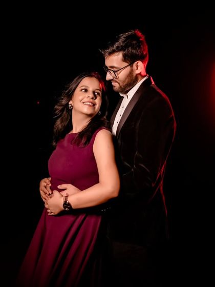 A dramatic and intimate studio portrait. The rich wine-colored dress and the groom-to-be's velvet blazer create a sophisticated look for a pre-wedding shoot.