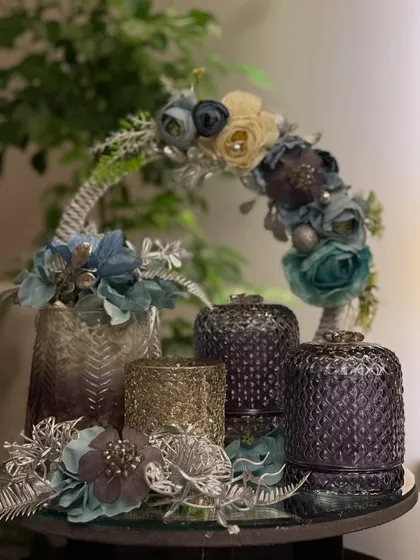 An elegant hamper in a cool blue and purple color palette. This arrangement sits on a mirror tray and includes textured jars and a floral basket handle, showing how we customize colors to match any theme.
