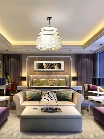 A grand master bedroom suite with a dedicated living area. The design features a classic chandelier, elegant purple armchairs, and large windows, creating a hotel-like luxury experience at home.
