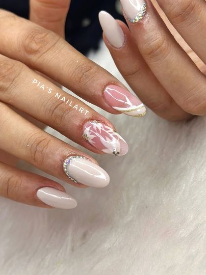 Engagement nails designed for a lovely client. We created a soft, elegant look with a milky white base, abstract art, and a delicate rhinestone cuff.
