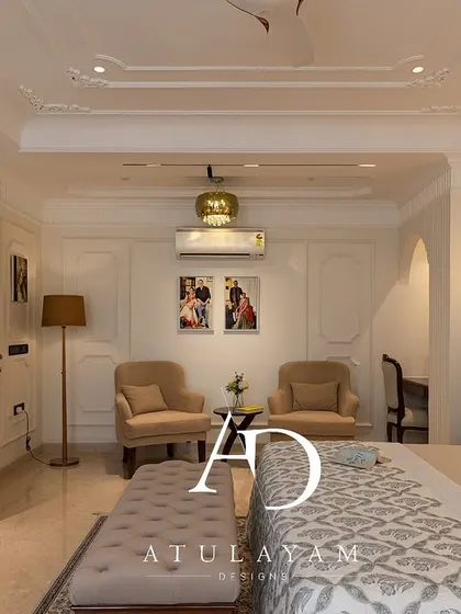 A wide shot of the master bedroom, showcasing its spacious layout with a dedicated seating area, study nook, and elegant classical details throughout.