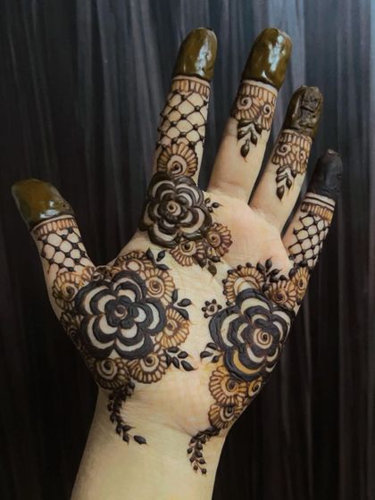 A gorgeous example of a bold floral design on the palm. The large, shaded flowers and net-patterned fingers create a beautiful and modern mehendi look.