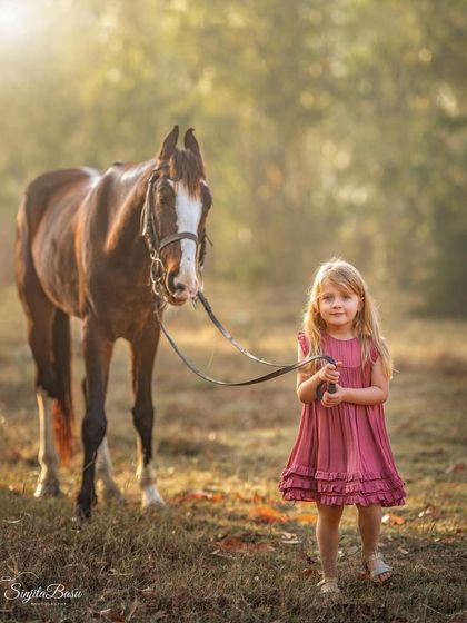 This little girl holding the reins of a majestic horse is the definition of a storybook portrait. It’s a moment of quiet confidence and a magical connection between a child and an animal.